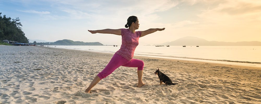 5 Ways to Stay Fit While Travelling - The Wise Traveller - Woman exercising on beach